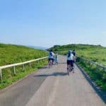 Cyclists riding through a lush green trail under clear blue skies at Wakka Nature Reserve in Hokkaido in July. A scenic and peaceful summer activity perfect for enjoying Hokkaido’s open landscapes and mild weather.
