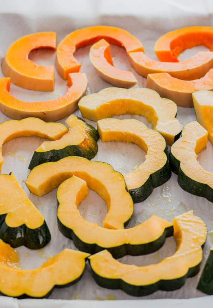 Acorn squash and butternut squash on a baking pan before baking