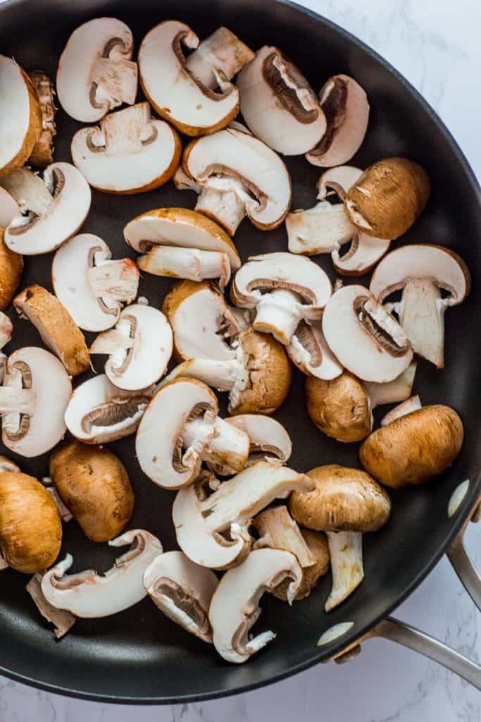 Sliced baby bella mushroom in the non-stick skillet before cooking