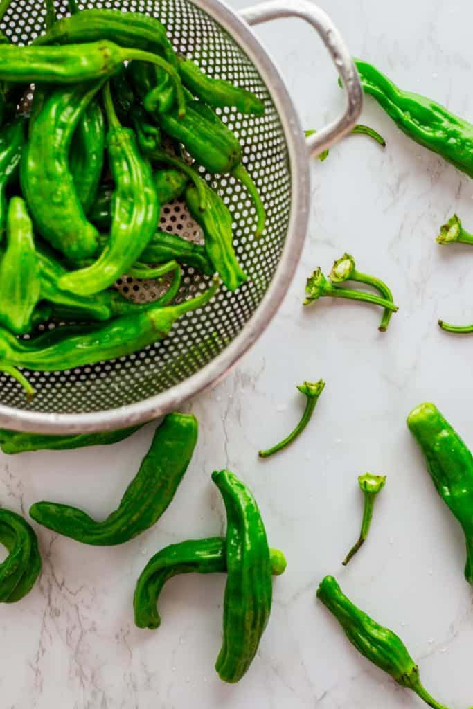 Washed shishito peppers and stems of the shishito peppers removed