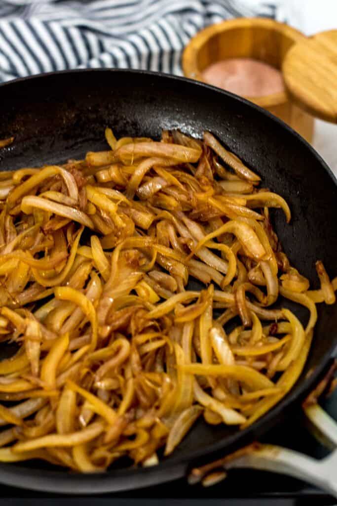 Onions caramelizing in a skillet as they develop golden brown color