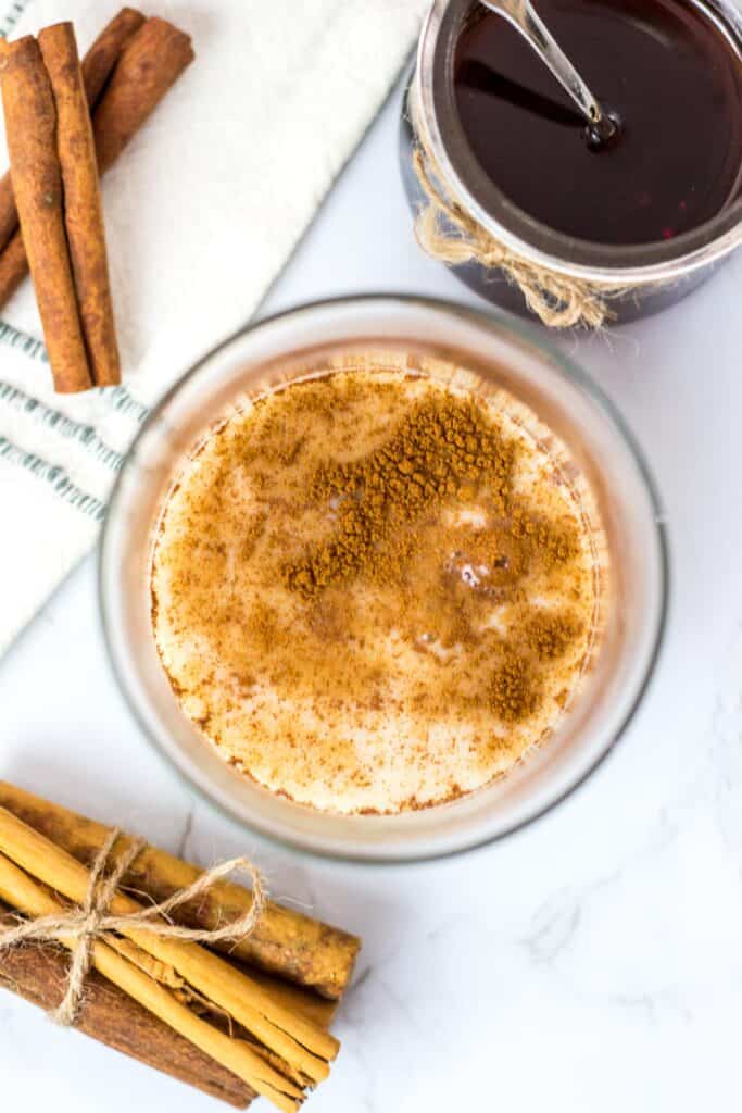 Glass with cinnamon and syrup mixed together for vegan horchata base.