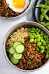 Vegan bulgogi bowl with quinoa, edamame, cucumbers, and plant-based bulgogi in a grey bowl