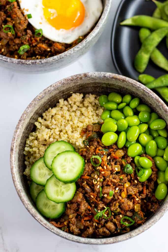 Vegan bulgogi bowl with quinoa, edamame, cucumbers, and plant-based bulgogi in a grey bowl