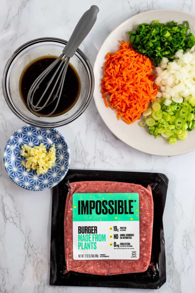 Ingredients for vegan bulgogi bowl including Impossible plant-based beef, carrots, green onion, garlic, and bulgogi sauce
