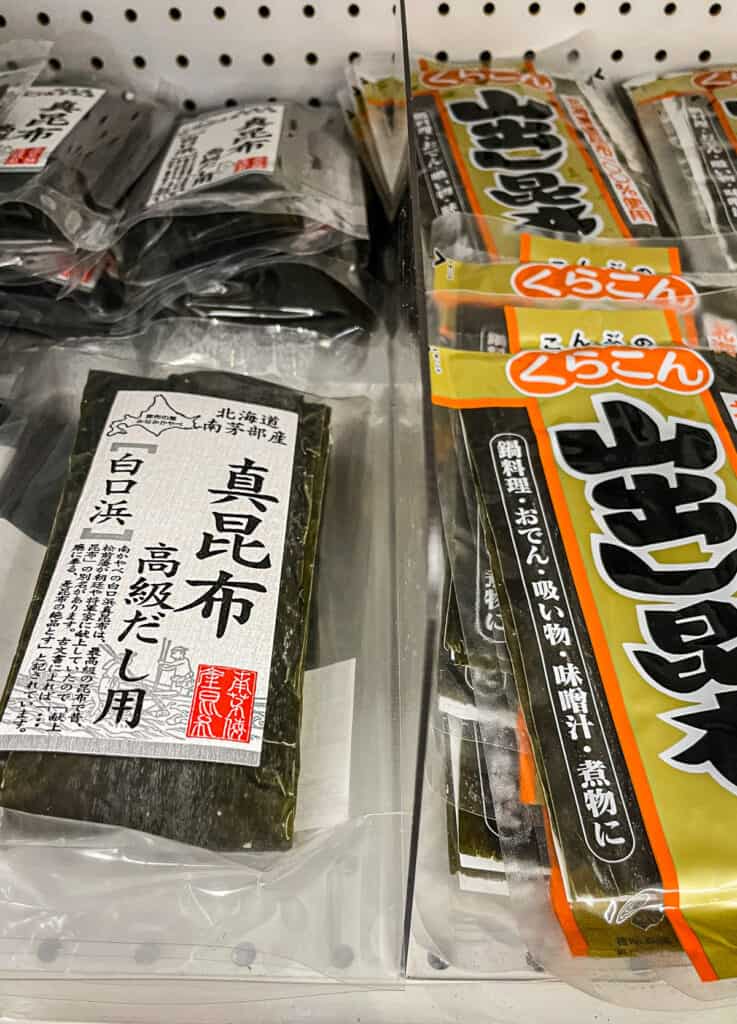Close-up of packaged kombu kelp sheets on a grocery store shelf, used to make dashi broth in Japanese cooking.