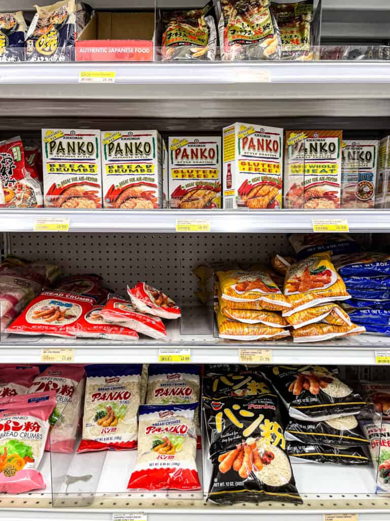 Boxes and bags of panko bread crumbs, including gluten-free and whole wheat options, displayed on a Japanese grocery store shelf.