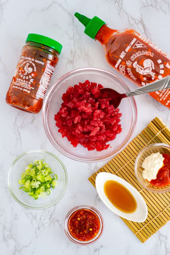 Spicy tuna recipe ingredients for sushi hand rolls, including diced sashimi‑grade tuna, chili garlic sauce, Sriracha, mayo, sesame oil, and green onion