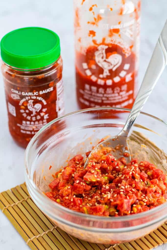Spicy tuna recipe for sushi filling mixed with chili garlic sauce, Sriracha, mayonnaise, sesame oil, and sprinkled with sesame seeds