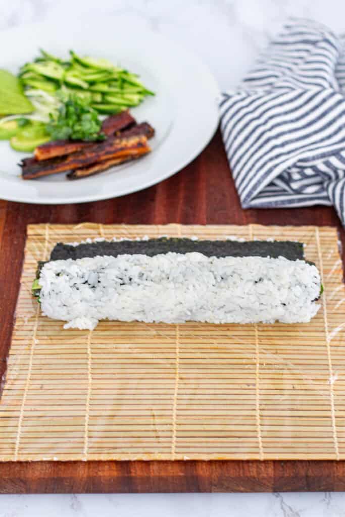 Hand-rolled unagi uramaki placed on sushi mat