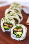 Close-up of unagi uramaki roll showing grilled eel, cucumber, and sprouts inside rice and nori, part of an easy homemade unagi uramaki recipe