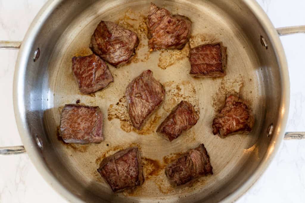 Browning beef cubes in a stainless steel pan for Japanese beef curry.
