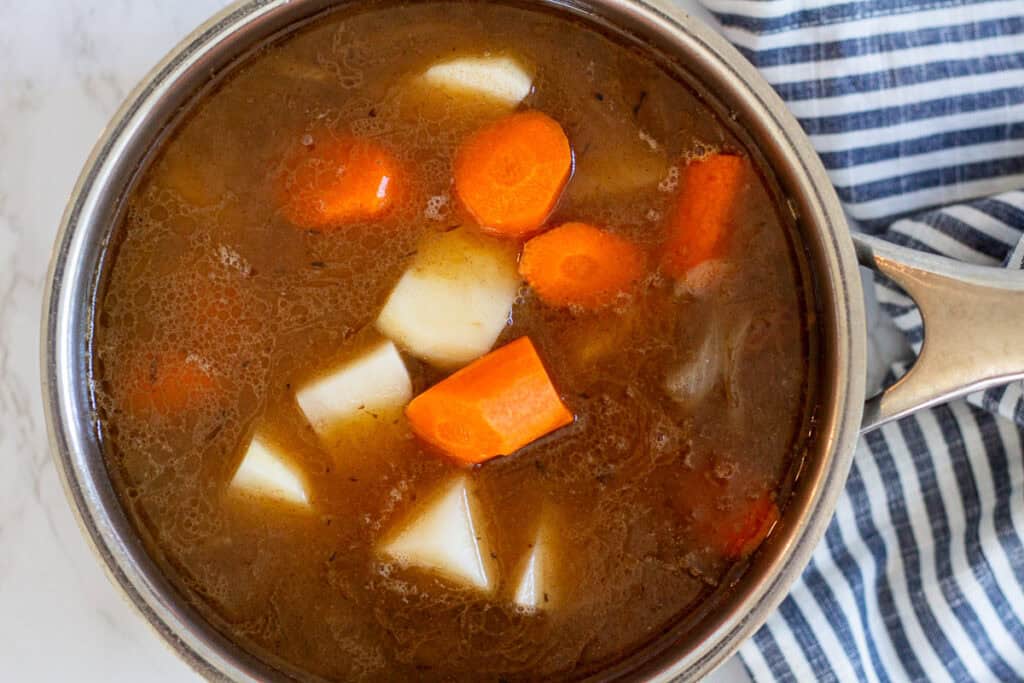 Carrots and potatoes simmering with beef and onions for homemade Japanese beef curry.
