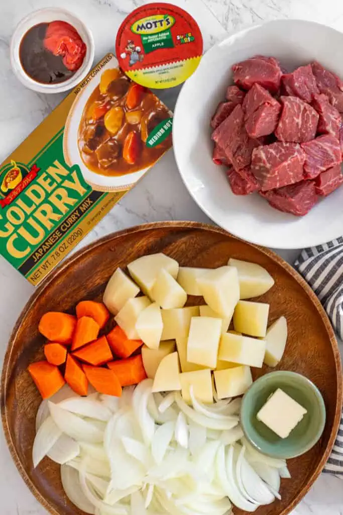 Raw beef cubes, onions, carrots, potatoes, butter, curry roux, and applesauce for Japanese beef curry.