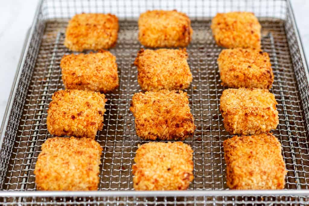 Crispy, golden brown mac and cheese bites fresh out of the air fryer basket.