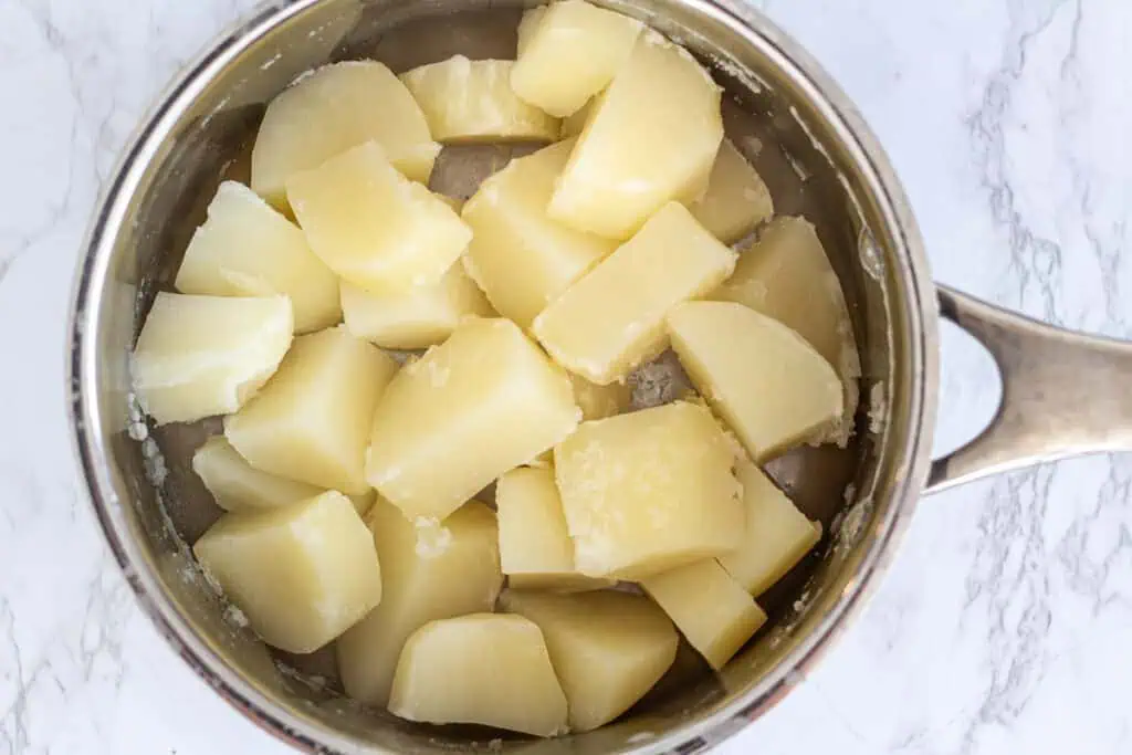 Cooked russet potatoes in a pot after boiling and drained