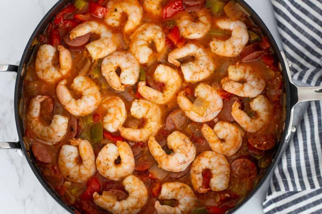 Shrimp cooked on top of Cajun sausage stew with tomatoes, peppers, and onions.