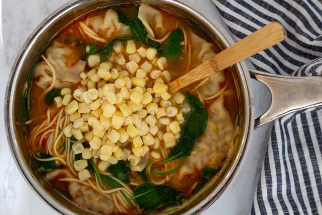 Baby spinach and corn added to dumpling noodle soup just before serving.