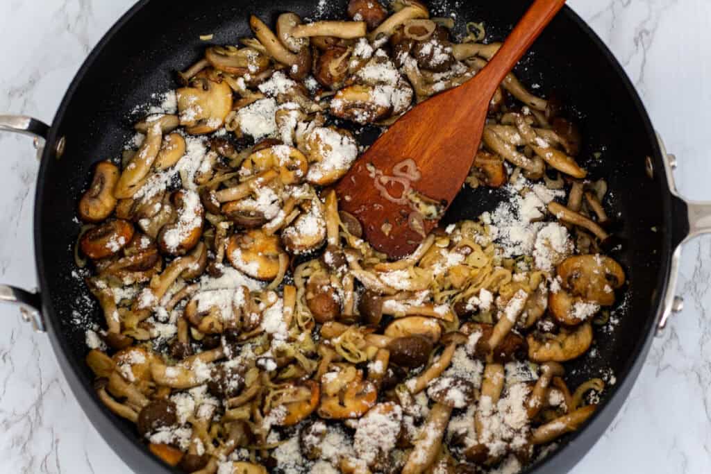 Flour sprinkled over mushrooms and aromatics to lightly thicken the pasta sauce