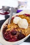 Warm cherry crisp with frozen cherries served with vanilla ice cream for two