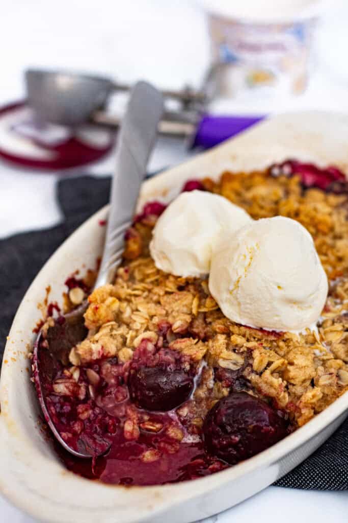 Warm cherry crisp with frozen cherries served with vanilla ice cream for two