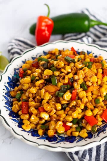 Simple skillet sautéed corn with bell peppers served on a plate, close-up view
