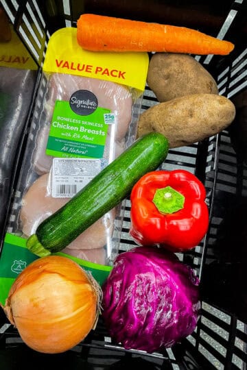 Grocery basket with chicken breast, fresh vegetables, and staples showing how to grocery shop for two and avoid food waste