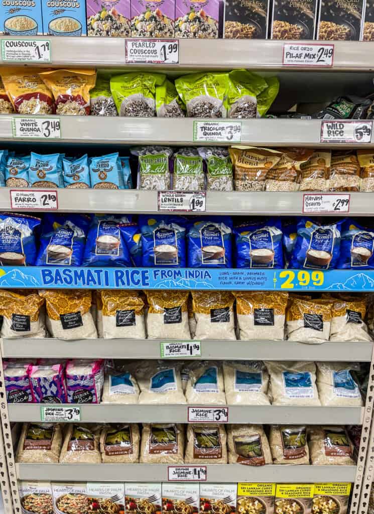Grocery store shelf with rice, quinoa, and grains in smaller packages showing how to buy the right amount when grocery shopping for two