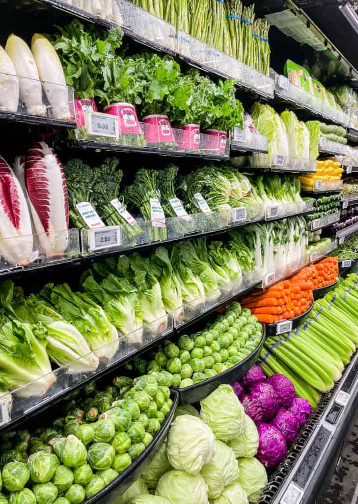 Loose vegetables and leafy greens at grocery store showing how to buy smaller amounts when grocery shopping for two