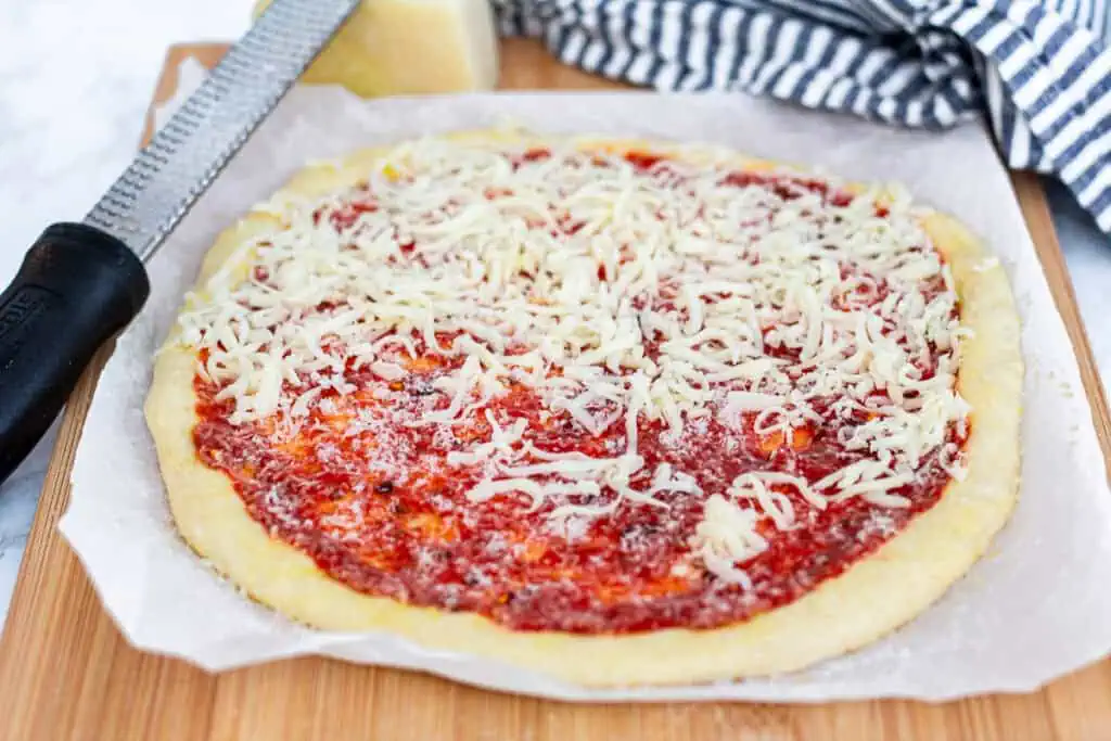 Homemade pizza with sauce and cheese on sourdough discard pizza dough