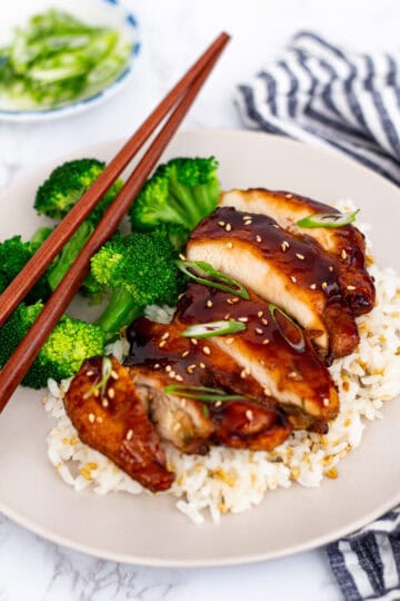 sticky air fryer teriyaki chicken thighs with sesame seeds and green onions over rice