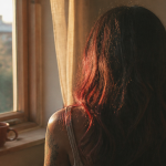 reflet rouge sur cheveux noir sous soleil couchant