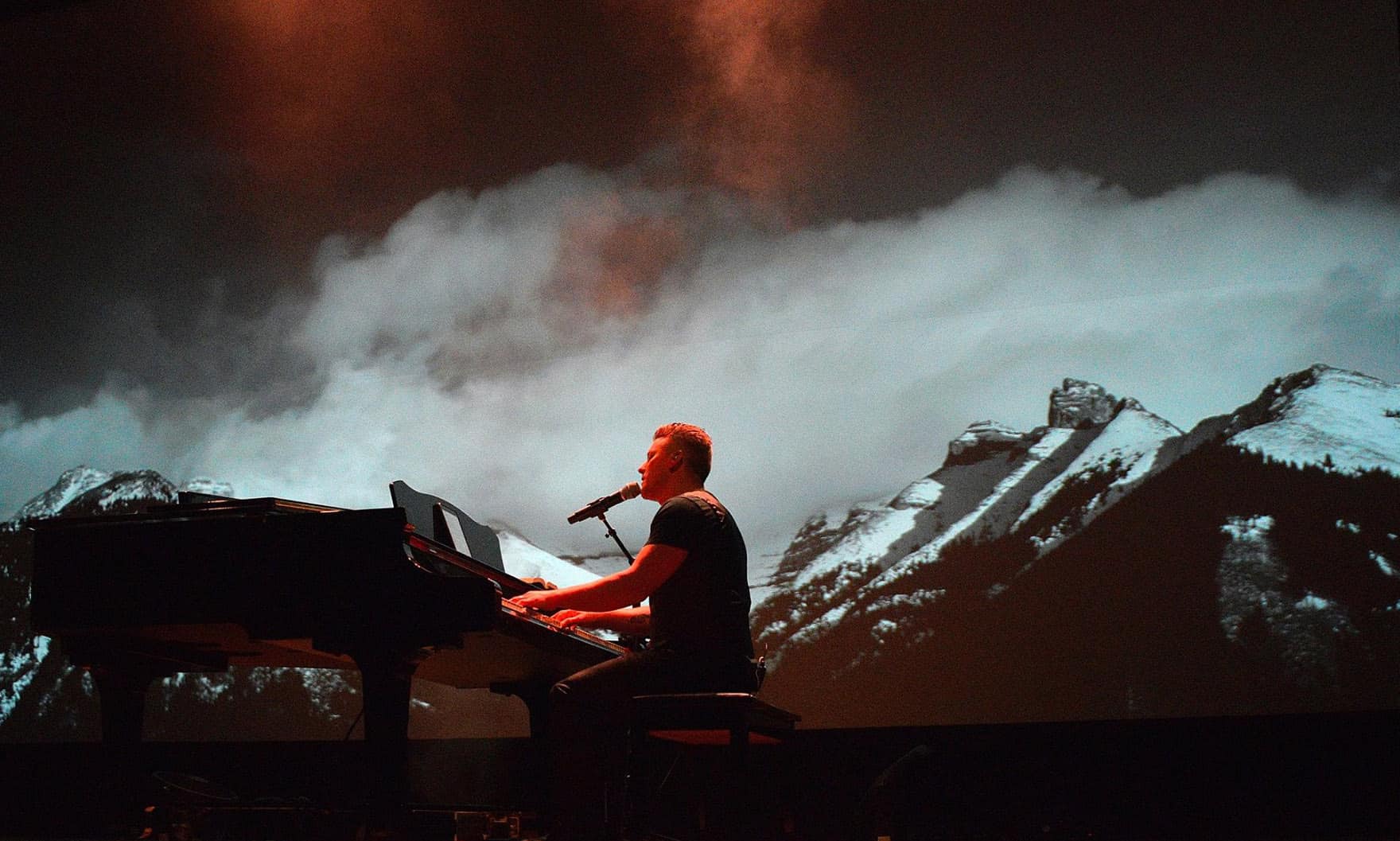 Musician playing piano on stage at NLW International event.