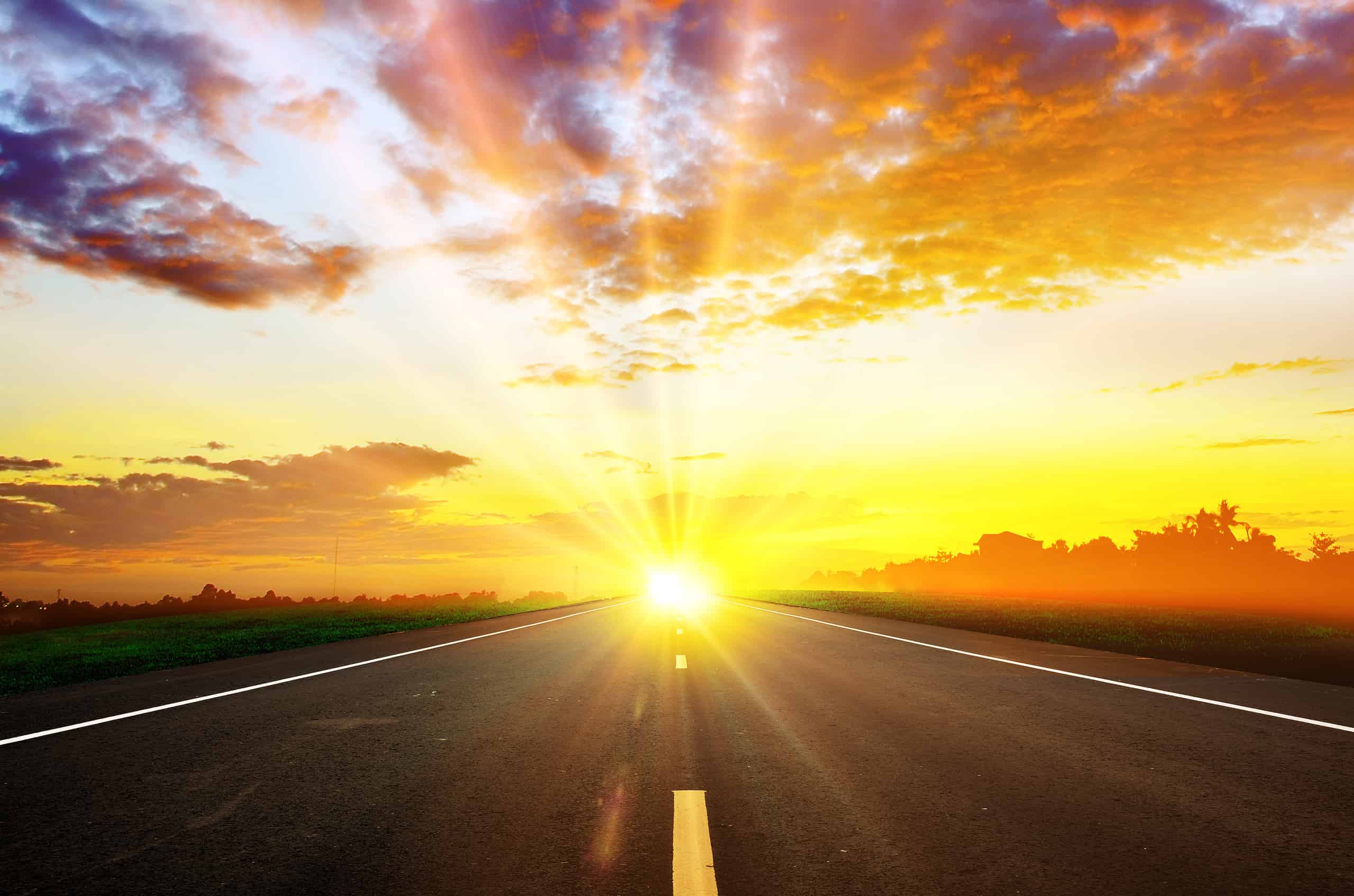 Beautiful sunrise over an empty road with vibrant sky and rays of sunlight.
