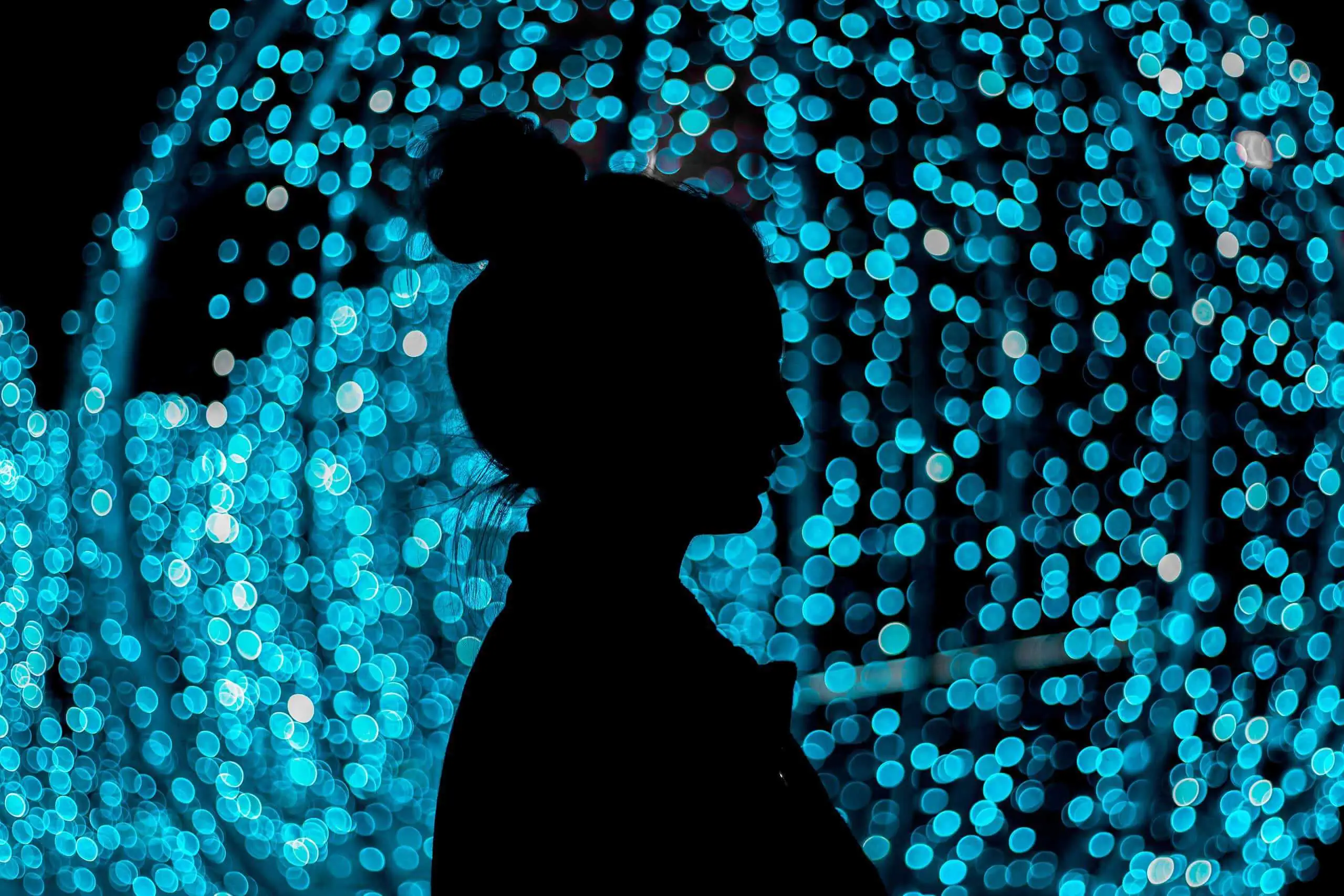 Silhouette of a woman with illuminated blue lights in the background at NLW International event.