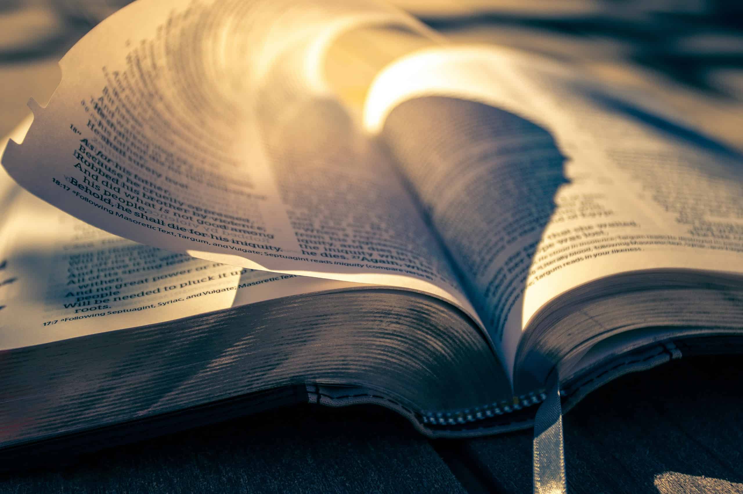 Bible open with pages illuminated by warm light, symbolizing spiritual growth and worship.