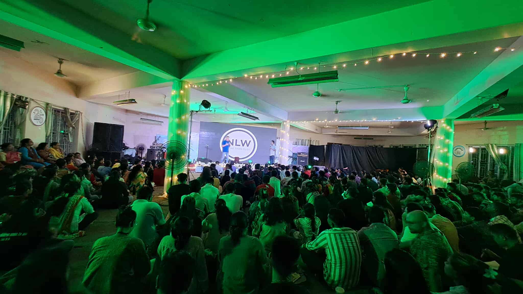 Bright green stage lighting creates engaging worship experience at NLW International event.