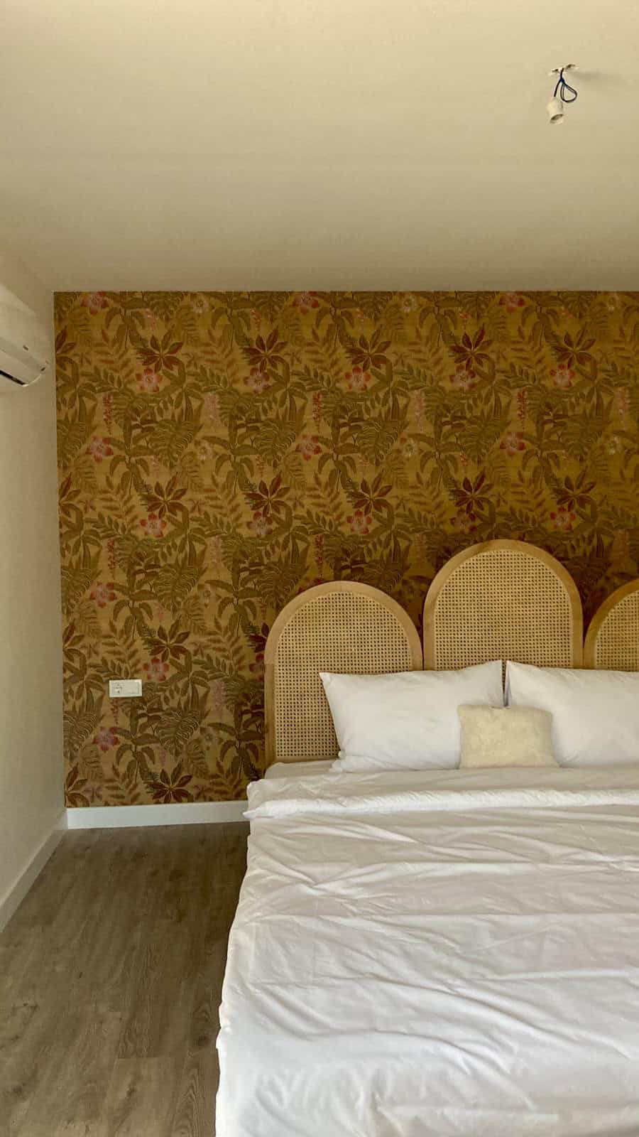 Cozy bedroom with floral wallpaper and rattan headboard in Eco Farm Villas, Gümüşlük Bodrum.