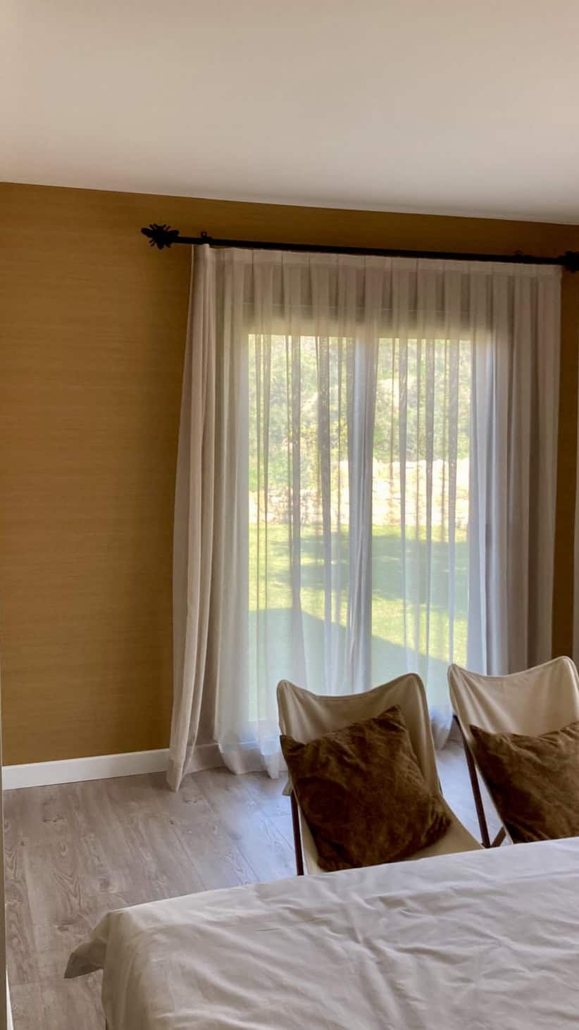 Cozy bedroom with large window and sheer curtains at ECO FARM VİLLALARI GÜMÜŞLÜK BODRUM.