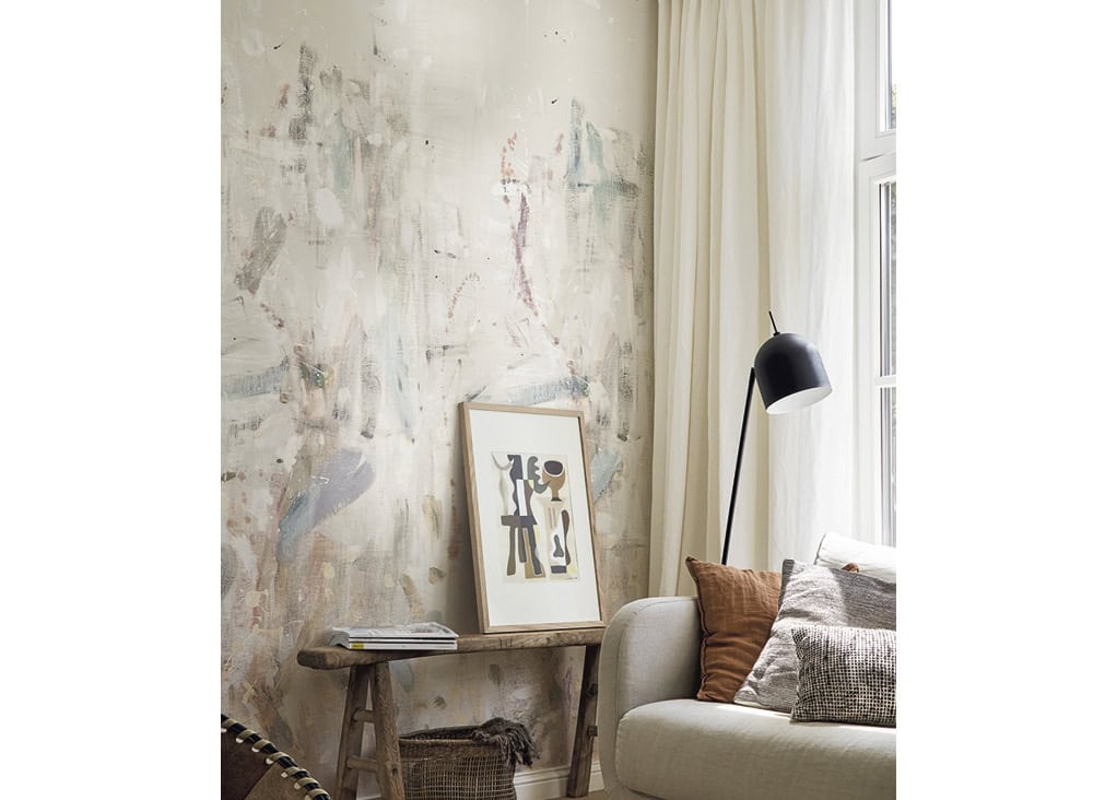 Modern living room with abstract wall art, cozy sofa, and natural light.