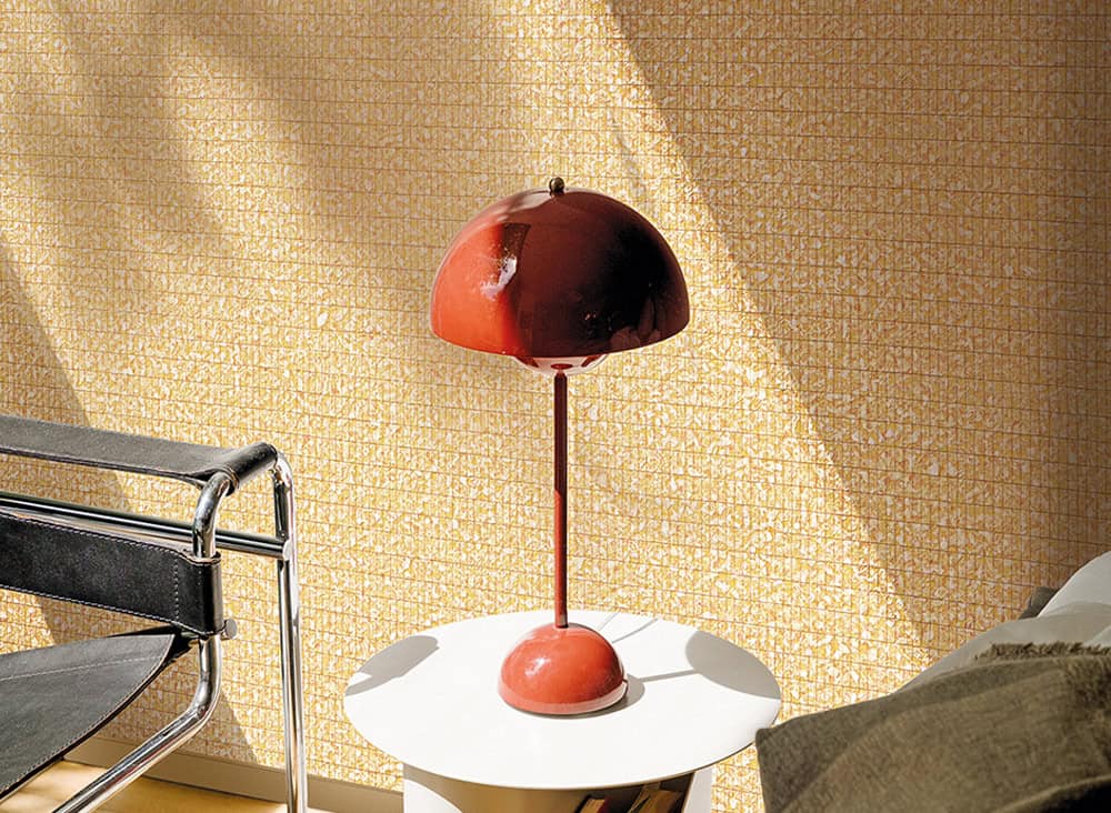 Modern red desk lamp on a white side table in a stylish room.