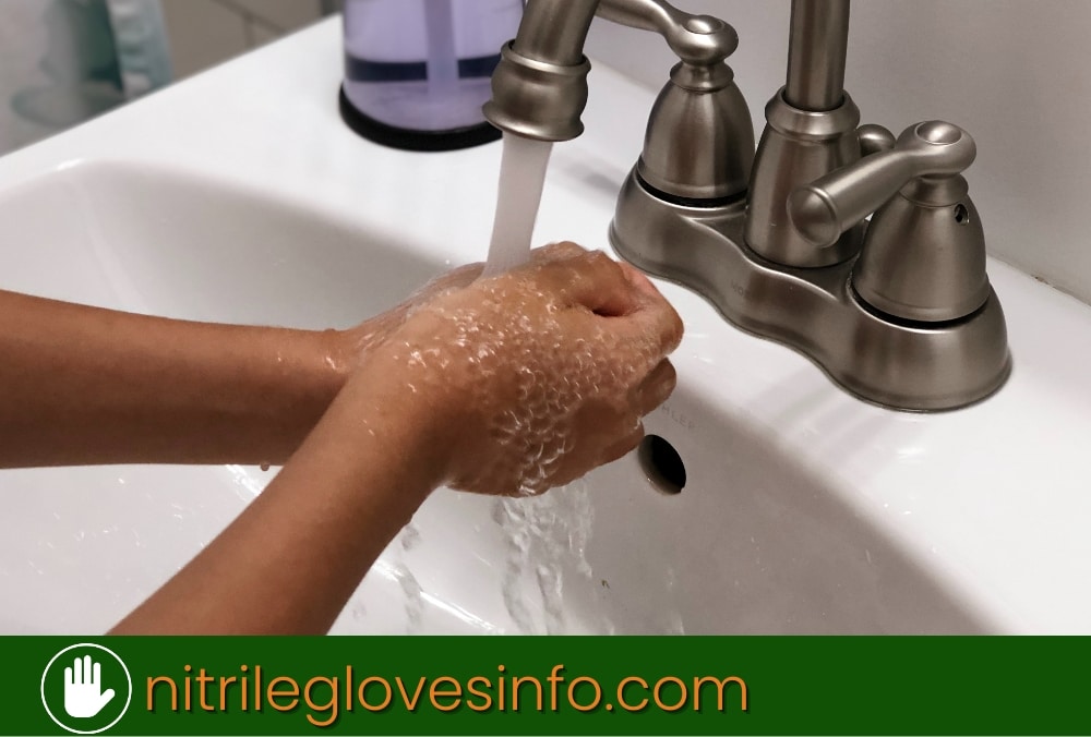 Person washing hands thoroughly under running water.