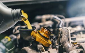 Pouring new motor oil into engine during oil change.