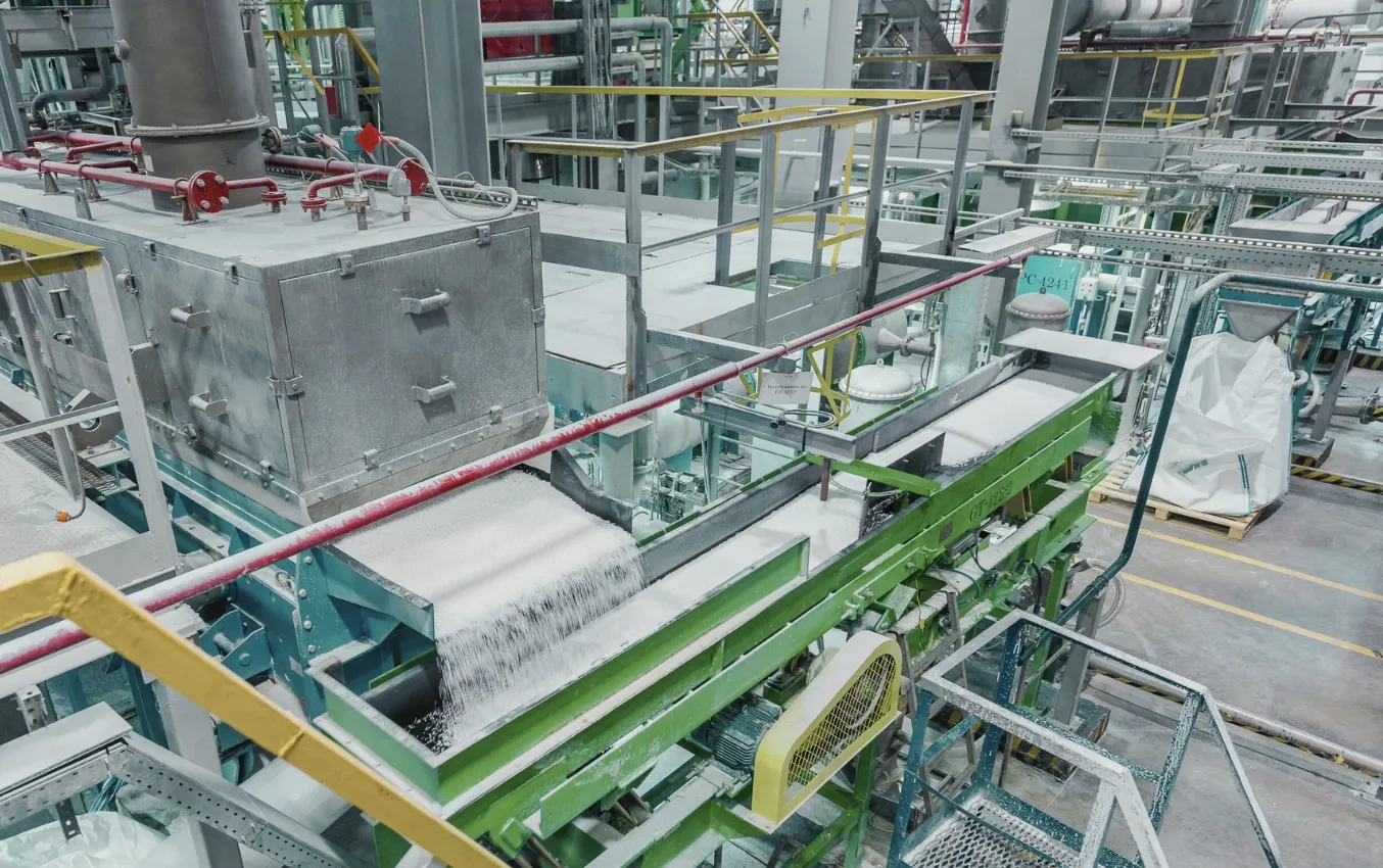 Industrial conveyor belt system processing nitrile rubber granules.