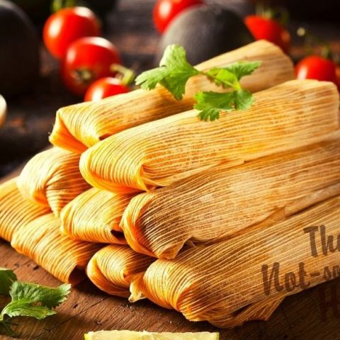 Mexican Pork Tamales Rojos Recipe | The Not so Modern Housewife Pork tamales on a board with salsa and cilantro