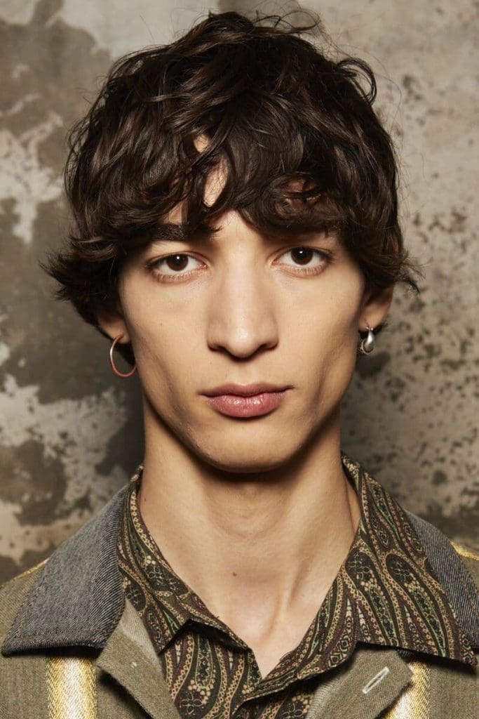 Corte de hombre mediano con flequillo y rizos.