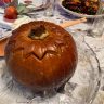 Ghapama the whole baked and stuffed pumpkin on a glass platter.