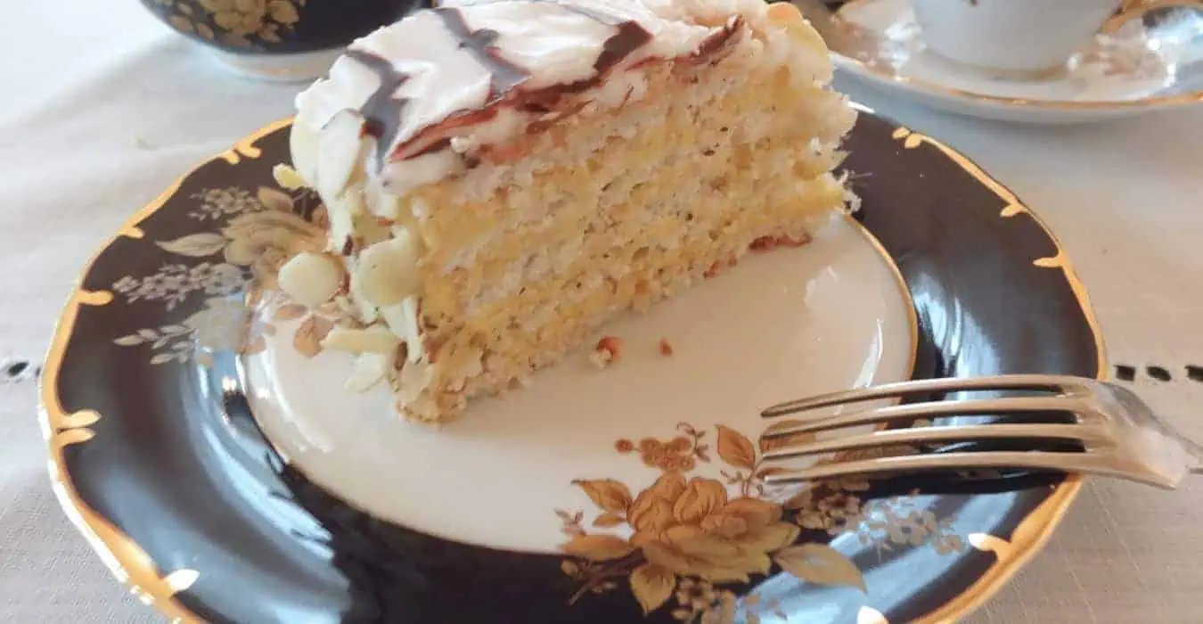 Slice of Esterházy Torte on a fine china plate.