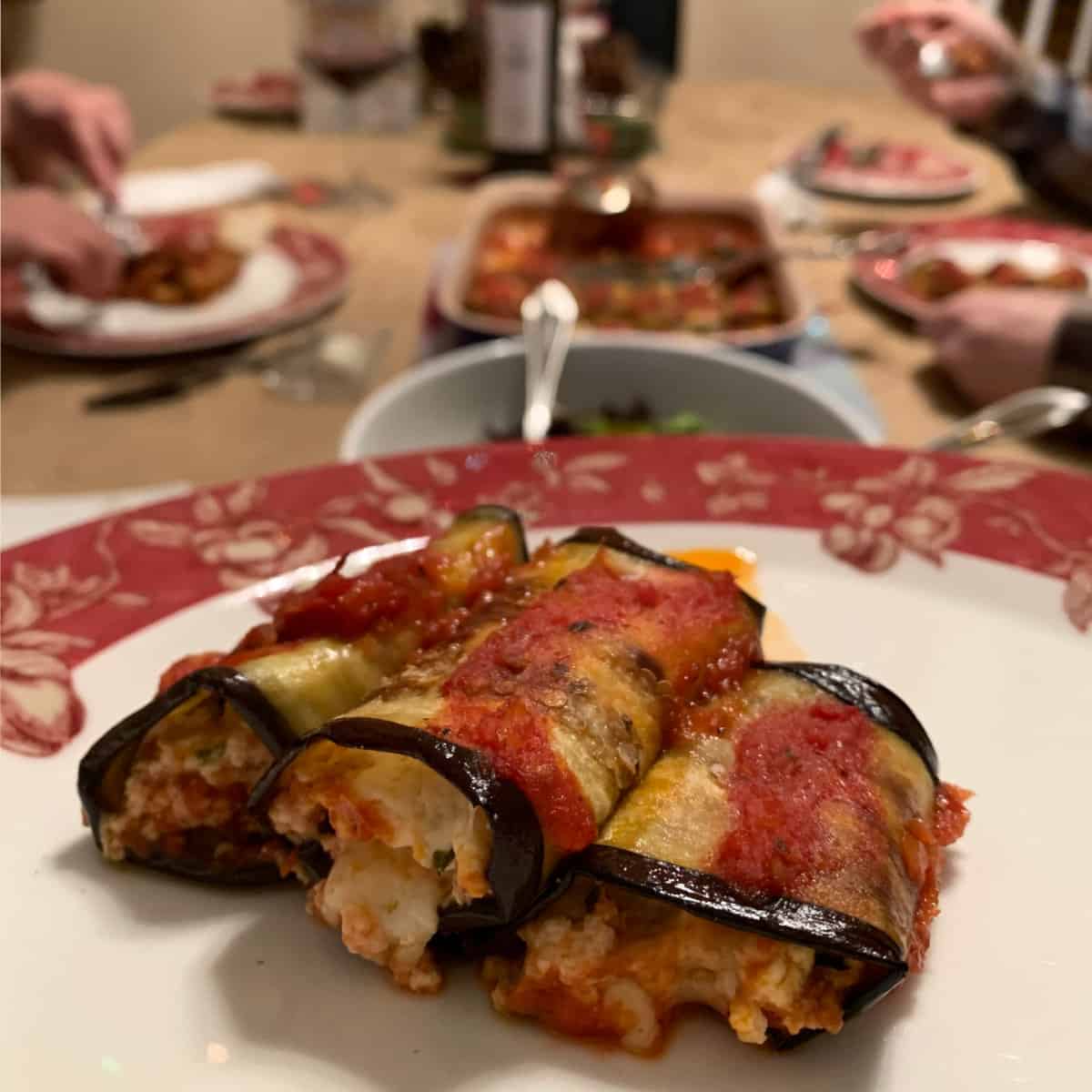 Dinner tables serving eggplant rollatini.