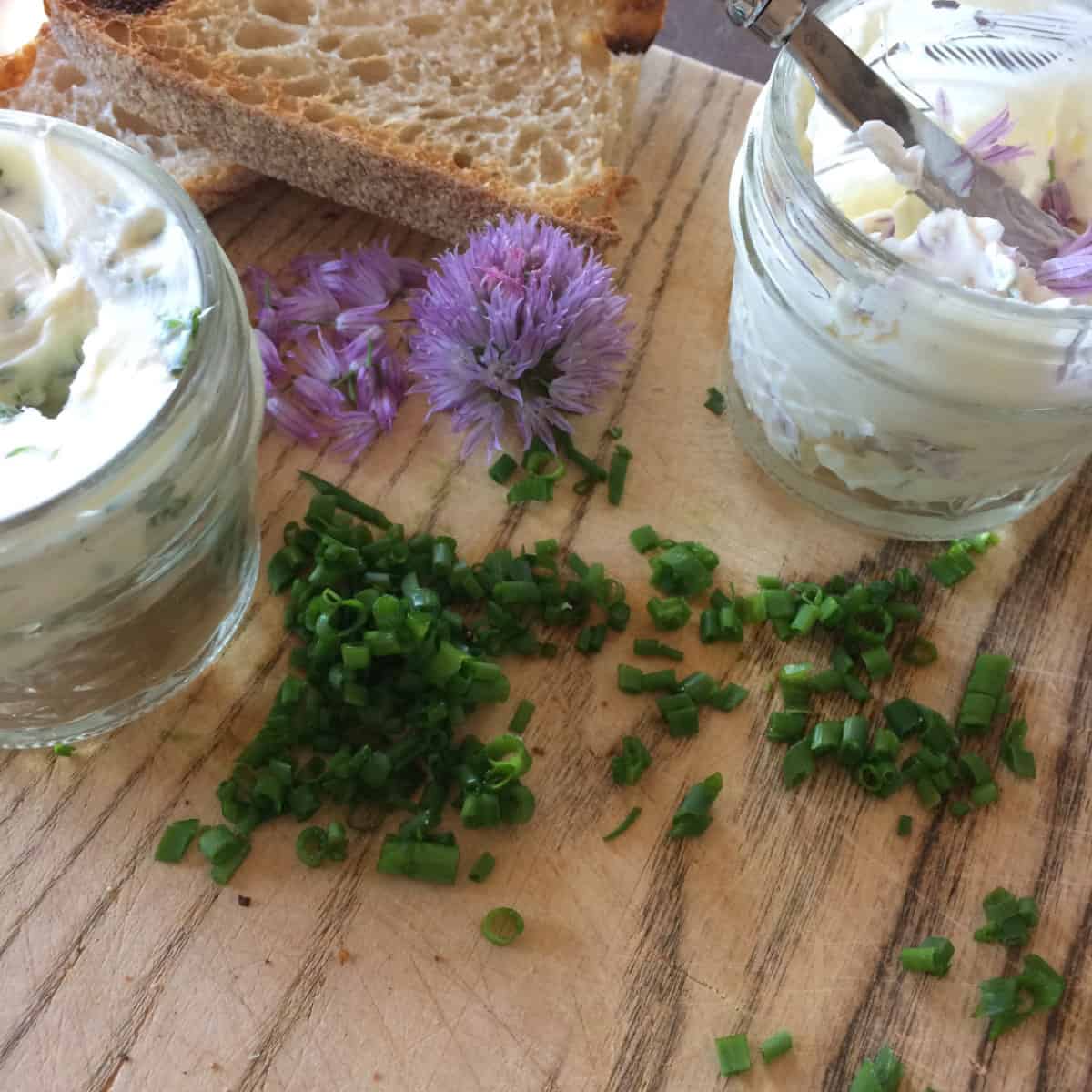 Chive flower butter in small jars with a toasted bread.